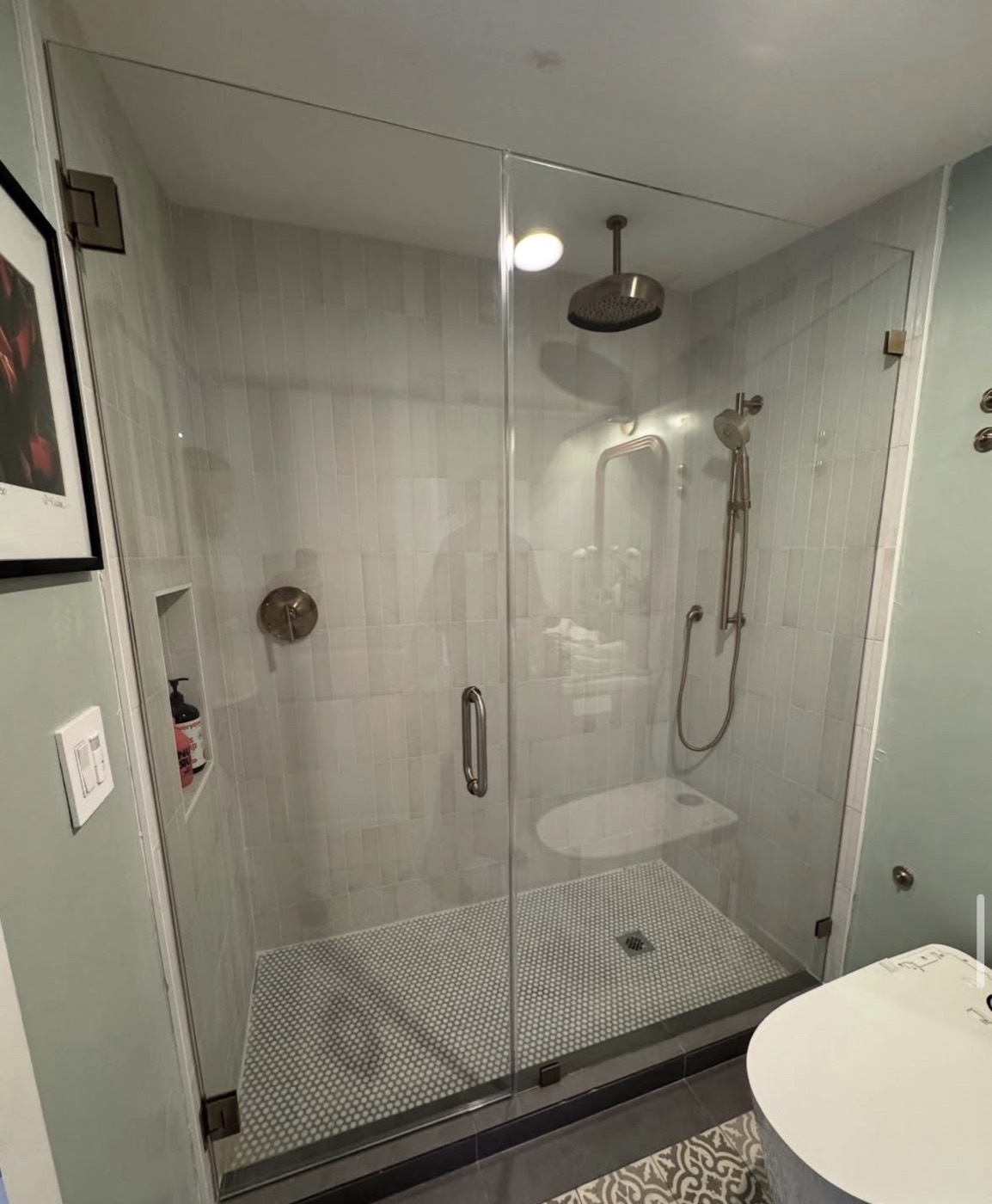 Hinged frameless shower door with rain head installed in a Miami bathroom