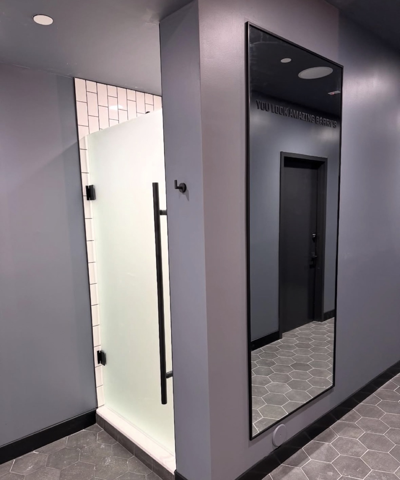 Black-framed full-length mirror installed in a boutique gym