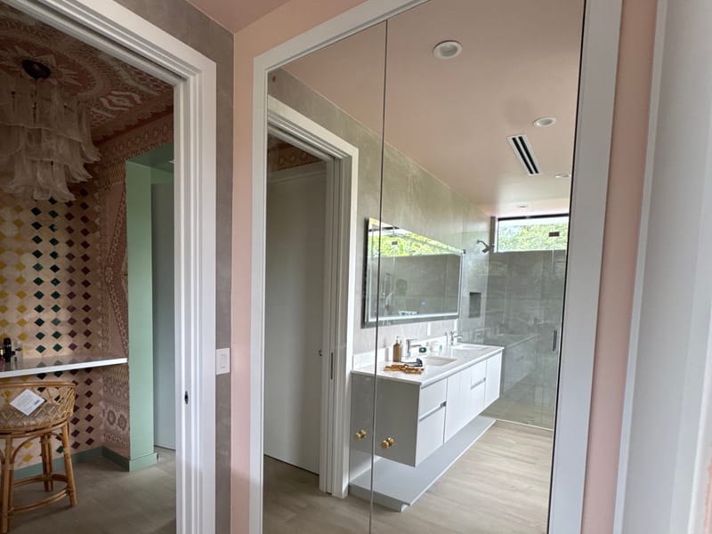 Mirrored closet doors reflecting the bathroom vanity, installed by Castilla Glass