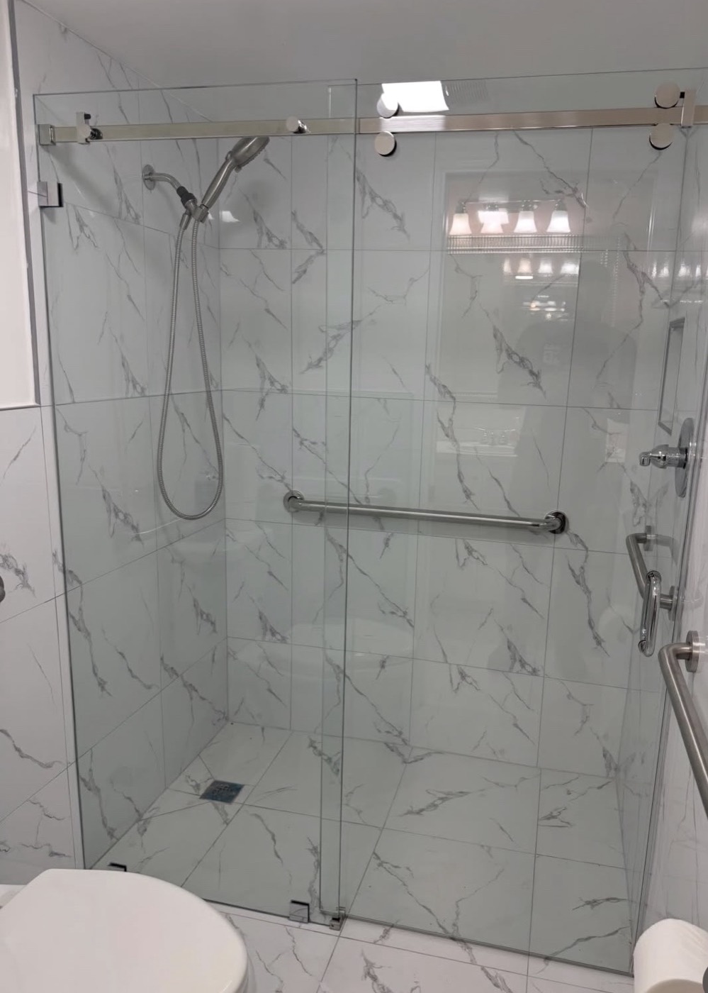 Frameless bypass shower door with marble-look tile