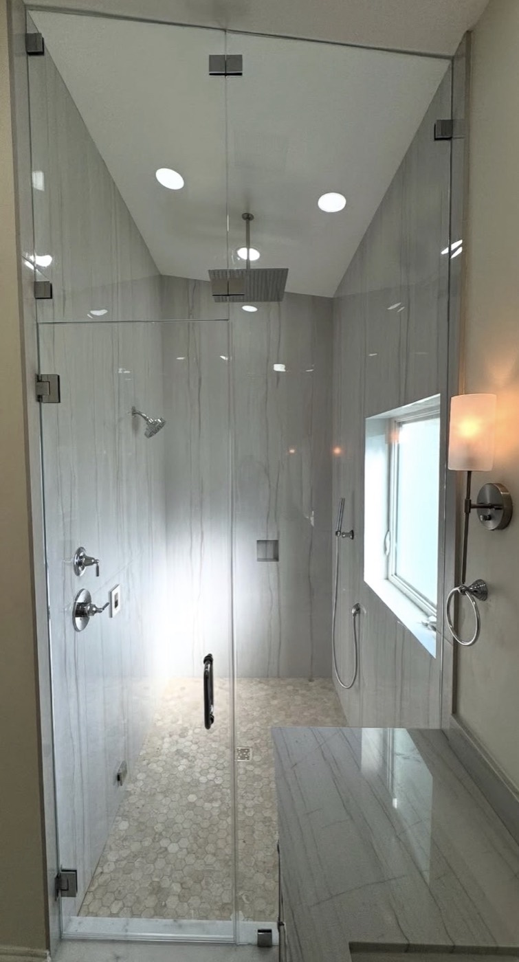 Floor-to-ceiling frameless steam shower enclosure with angled glass